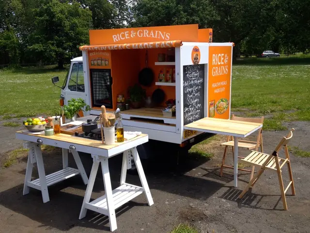 A Piaggio Ape converted into a mobile kitchen with a hob, prep counter and seating